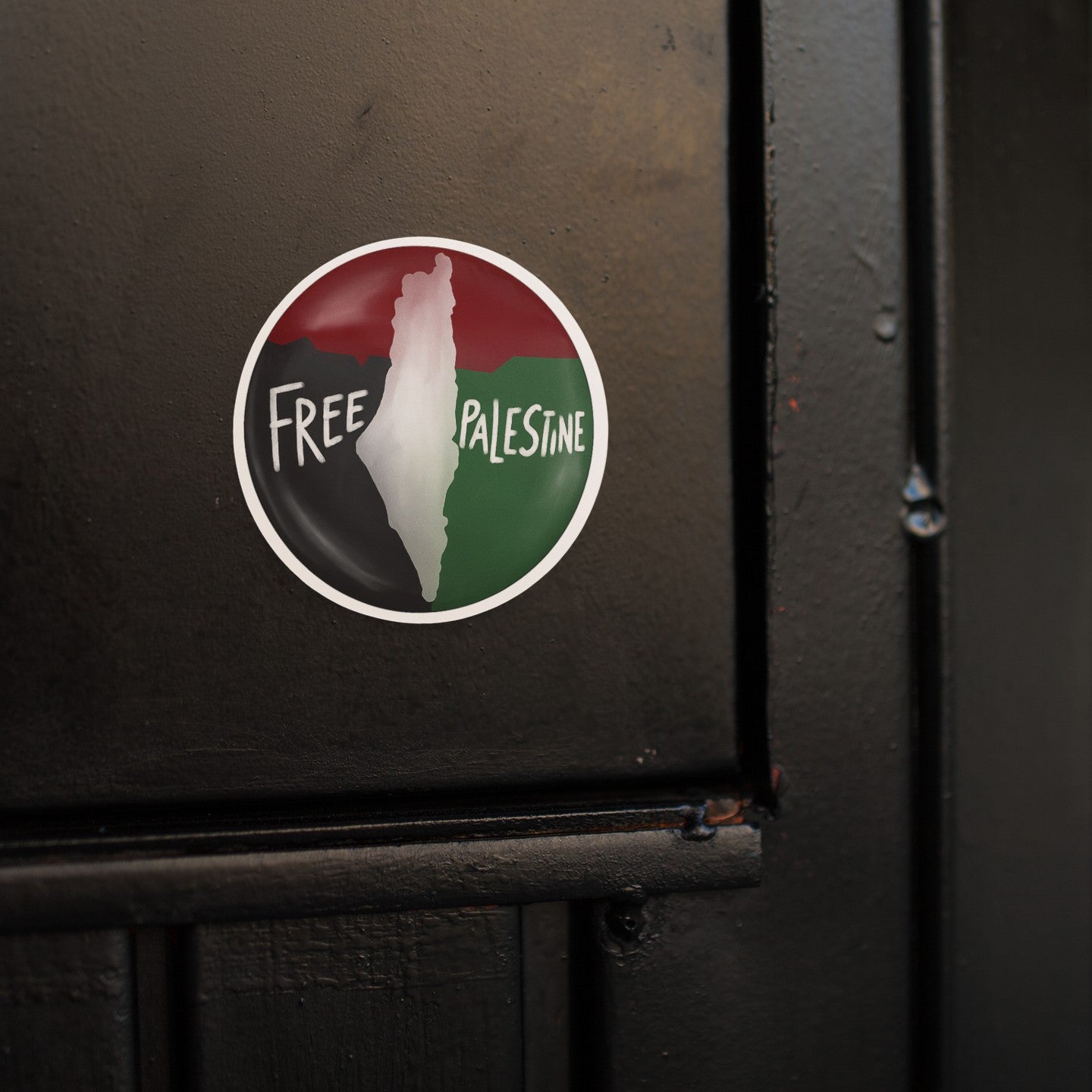 Sticker with 'Free Palestine' text on a black surface