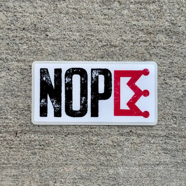 Sticker with 'NOPE' text on a textured surface