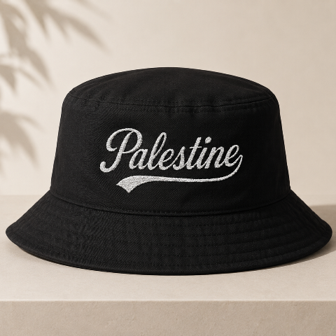 Black bucket hat with 'Palestine' embroidery on a beige background