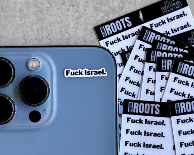 Phone with 'Fuck Israel' sticker and multiple sheets of stickers on a textured surface