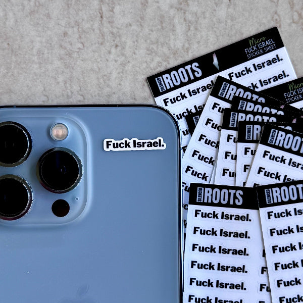 Phone with 'Fuck Israel' sticker and multiple sheets of stickers on a textured surface
