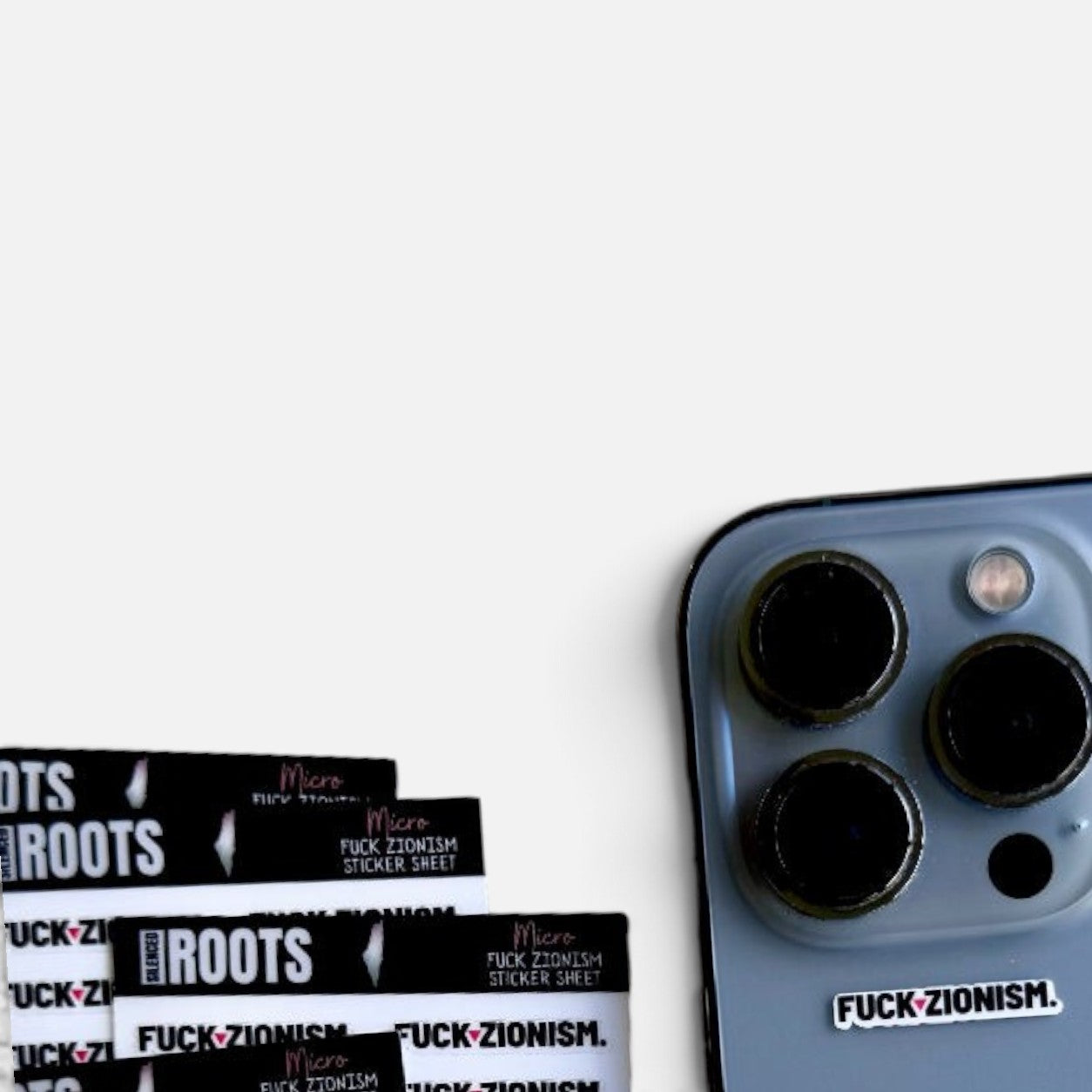 Silenced Roots sticker sheet with black and white micro protest decals applied to a smartphone camera housing