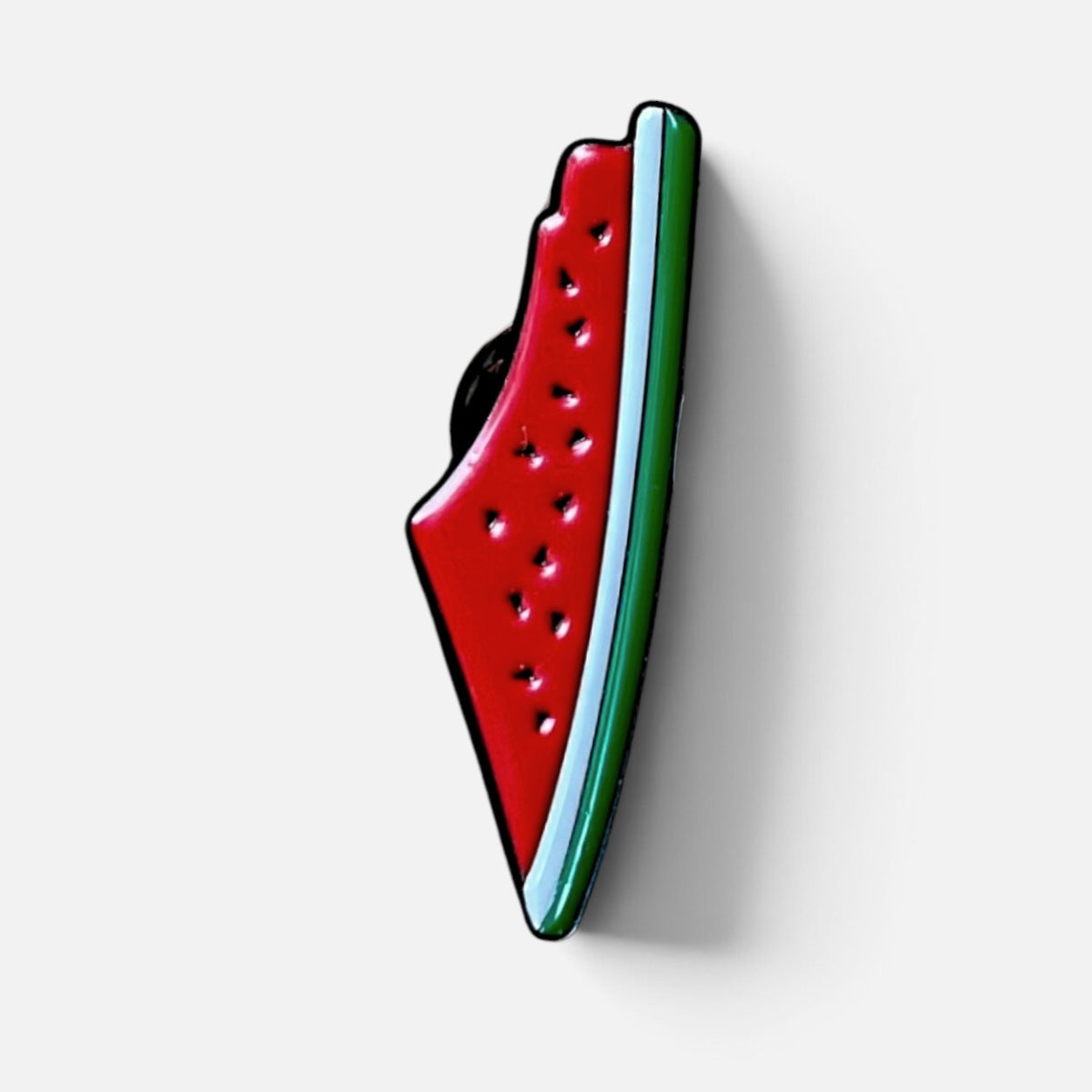Silenced Roots enamel pin shaped like a slice of watermelon in the silhouette of historic Palestine